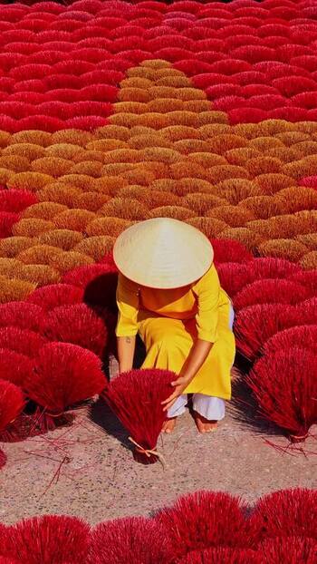View of a person among bundles of incense sticks Vietnam.