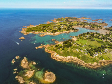 Aerial view of the island of Brehat with its rocky coastline emerald waters scattered houses and green fields in Ile de Brehat Brittany France.