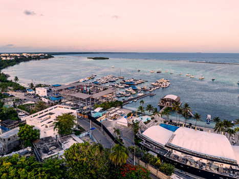 Aerial view of Club Nautico de Santo Domingo Inc. with boats docked in the marina palm trees a pool and coastal buildings in Andres Santo Domingo Dominican Republic. Aerial view of Club Nautico de Santo Domingo Inc. with boats docked in the marina palm trees a pool and coastal buildings in Andres Santo Domingo Dominican Republic.