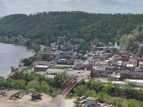 Aerial view of historic brick buildings church steeples and a bridge along the riverbank under a cloudy sky in Aurora Indiana United States. Aerial view of historic brick buildings church steeples and a bridge along the riverbank under a cloudy sky in Aurora Indiana United States.