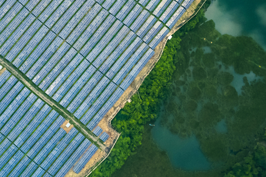 Kaptai Chittagong Division Bangladesh 06 September 2025 Aerial view of Kaptai Solar Power Plant with rows of solar panels next to lush forest and Kaptai Lake.