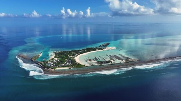 Aerial view of a resort island and turquoise lagoons Thulusdhoo Maldives.
