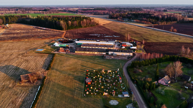 Aerial view of a paintball field with various obstacles situated next to a farm complex and agricultural fields in the rural landscape of Latvia. Aerial view of a paintball field with various obstacles situated next to a farm complex and agricultural fields in the rural landscape of Latvia.