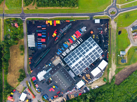 Aerial view of a pipe manufacturing facility with solar panels on the warehouse roof organized storage yards with colorful pipes and surrounding green landscape in Jelgava Latvia. Aerial view of a pipe manufacturing facility with solar panels on the warehouse roof organized storage yards with colorful pipes and surrounding green landscape in Jelgava Latvia.