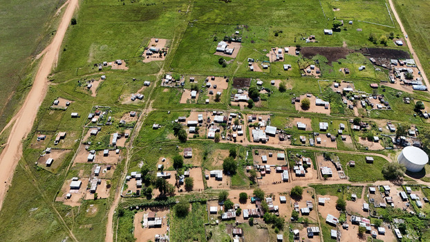 Aerial view of the Alma settlement featuring small houses with corrugated roofs and dirt roads surrounded by green fields in Waterberg District Municipality Limpopo South Africa. Aerial view of the Alma settlement featuring small houses with corrugated roofs and dirt roads surrounded by green fields in Waterberg District Municipality Limpopo South Africa.