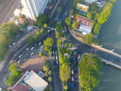 Surabaya Indonesia 05 August 2026 Aerial view of a busy urban intersection with heavy traffic motorcycles and cars crossing a bridge over a river. Surabaya Indonesia 05 August 2026 Aerial view of a busy urban intersection with heavy traffic motorcycles and cars crossing a bridge over a river.