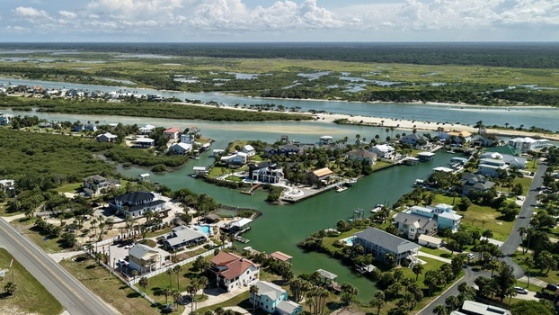 Aerial view of Matanzas Inlet featuring waterfront residential homes lush mangroves winding waterways and coastal vegetation in St. Johns County Florida United States. Aerial view of Matanzas Inlet featuring waterfront residential homes lush mangroves winding waterways and coastal vegetation in St. Johns County Florida United States.