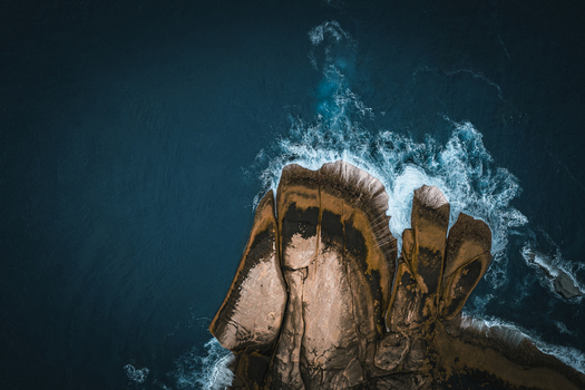 Aerial view of Bettys Beach with rugged rock formations and crashing waves along the coastline in Albany WA Australia. Aerial view of Bettys Beach with rugged rock formations and crashing waves along the coastline in Albany WA Australia.