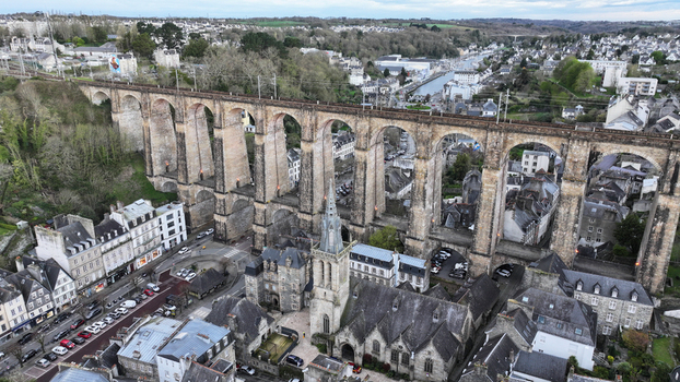 Aerial view of the Eglise Saint Melaine and the massive stone railway viaduct spanning the valley surrounded by traditional slate roofed buildings and urban streets Morlaix Bretagne France. Aerial view of the Eglise Saint Melaine and the massive stone railway viaduct spanning the valley surrounded by traditional slate roofed buildings and urban streets Morlaix Bretagne France.