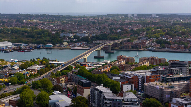 Aerial view of the Itchen Bridge spanning the River Itchen with urban buildings lush greenery and traffic in Southampton England United Kingdom. Aerial view of the Itchen Bridge spanning the River Itchen with urban buildings lush greenery and traffic in Southampton England United Kingdom.