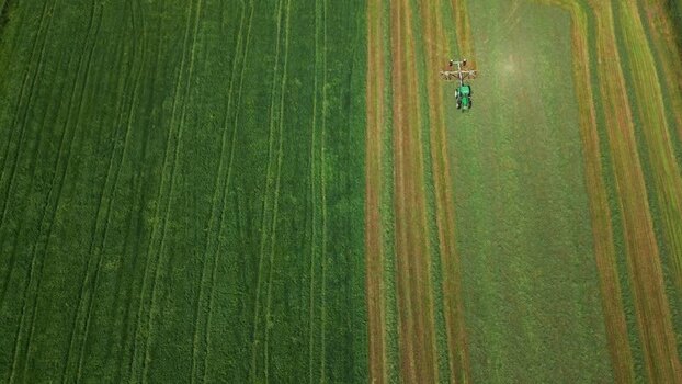 Aerial view of a tractor working in a green field in Norway.