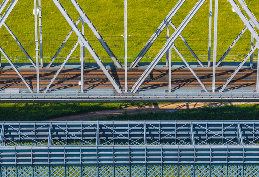 Aerial view of the historic steel truss railway bridge with visible tracks and green embankments in Tczew Pomeranian Voivodeship Poland. Aerial view of the historic steel truss railway bridge with visible tracks and green embankments in Tczew Pomeranian Voivodeship Poland.