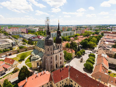 Aerial view of St. Nicolas Basilica with its twin spires under renovation surrounded by historic red roofed buildings and lush green trees in Trnava Trnava Region Slovakia. Aerial view of St. Nicolas Basilica with its twin spires under renovation surrounded by historic red roofed buildings and lush green trees in Trnava Trnava Region Slovakia.
