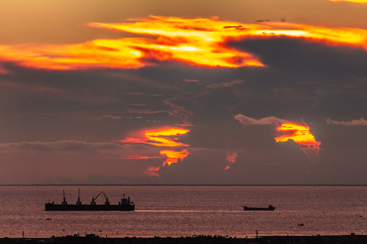 Chattogram Bangladesh 01 September 2021 Aerial view of cargo ships sailing on the sea during a dramatic sunset with vibrant orange and yellow clouds filling the sky.
