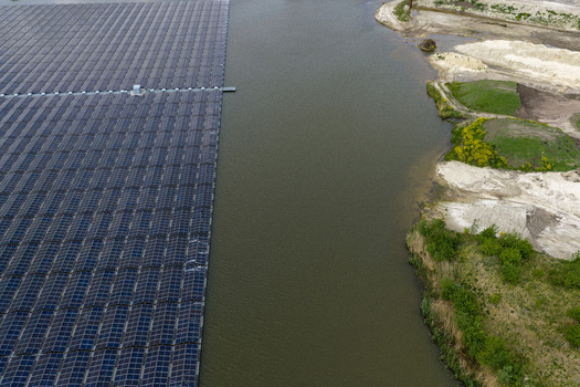 Aerial view of a large floating solar farm on a calm lake next to a sand extraction site with green hills and sand piles Beilen Drenthe Netherlands. Aerial view of a large floating solar farm on a calm lake next to a sand extraction site with green hills and sand piles Beilen Drenthe Netherlands.