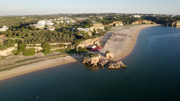 Aerial view of the sandy beach and rocky cliffs along the coastline of Ferragudo Faro District Portugal.