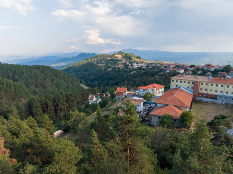 Aerial view of the village of Sveta Petka with its red roofed buildings nestled among dense pine forests and rolling mountains under a cloudy sky in Sveta Petka Pazardzhik Bulgaria. Aerial view of the village of Sveta Petka with its red roofed buildings nestled among dense pine forests and rolling mountains under a cloudy sky in Sveta Petka Pazardzhik Bulgaria.