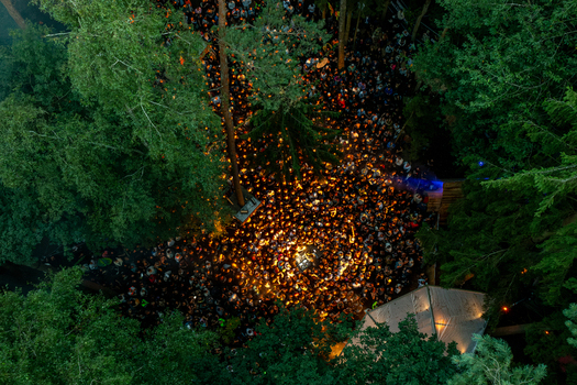 Herzogenaurach Germany 27 July 2025 Aerial view of the Open Beatz Festival with a large crowd gathered among tall trees in a forest illuminated by warm lights. Herzogenaurach Germany 27 July 2025 Aerial view of the Open Beatz Festival with a large crowd gathered among tall trees in a forest illuminated by warm lights.