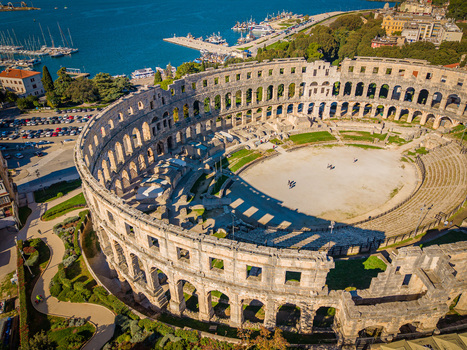 Aerial view of the ancient Roman amphitheater standing proudly against the azure sea a testament to history and human ingenuity Pula Istria County Croatia.