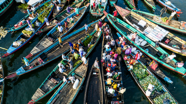 Rangamati Bangladesh 19 October 2022 Aerial view of a bustling floating market with numerous wooden boats filled with fresh produce and local people navigating the water.