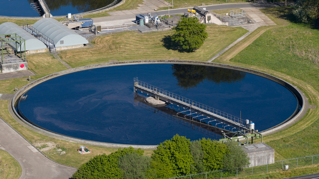 Aerial view of the RWZI Echten wastewater treatment plant featuring a large circular sedimentation tank and industrial facilities in Hoogeveen Drenthe Netherlands. Aerial view of the RWZI Echten wastewater treatment plant featuring a large circular sedimentation tank and industrial facilities in Hoogeveen Drenthe Netherlands.