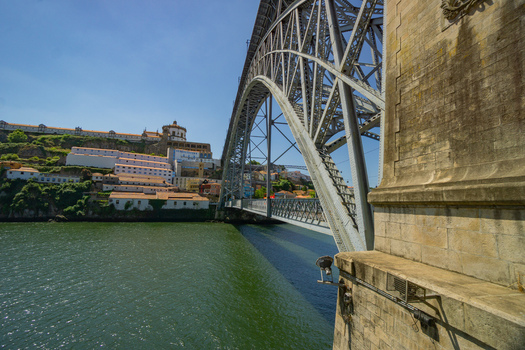Porto Portugal 13 July 2021 View of the iconic Dom Luís I Bridge s metallic arch soaring over the shimmering Douro River framed by the ancient city s weathered stone architecture. Porto Portugal 13 July 2021 View of the iconic Dom Luís I Bridge s metallic arch soaring over the shimmering Douro River framed by the ancient city s weathered stone architecture.