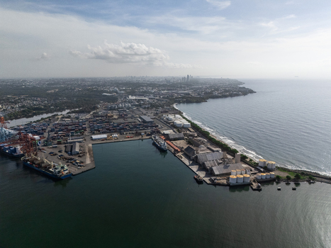 Aerial view of the industrial port with shipping containers cargo ships and storage tanks along the coastline in Bajos de Haina San Cristobal Province Dominican Republic.