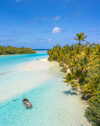Aerial view of Aitutaki One Foot Island with a boat in the turquoise lagoon surrounded by palm trees and white sandy beaches Arutanga Cook Islands. Aerial view of Aitutaki One Foot Island with a boat in the turquoise lagoon surrounded by palm trees and white sandy beaches Arutanga Cook Islands.