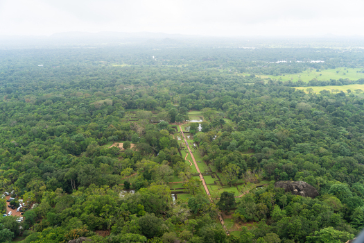 View of the ancient royal gardens and symmetrical pathways surrounded by dense tropical jungle and misty hills in Sigiriya Central Province Sri Lanka. View of the ancient royal gardens and symmetrical pathways surrounded by dense tropical jungle and misty hills in Sigiriya Central Province Sri Lanka.