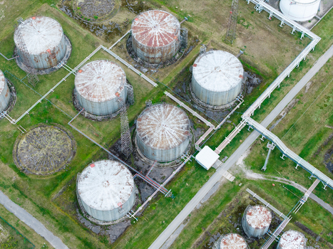 Aerial view of large industrial storage tanks arranged in a grid pattern with connecting pipelines and access roads in Olaine parish Olaine Municipality Latvia.