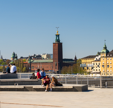 Stockholm Sweden 02 May 2026 View of people sitting on benches at Sodermalmstorg with the Stockholm City Hall tower in the background under a clear blue sky. Stockholm Sweden 02 May 2026 View of people sitting on benches at Sodermalmstorg with the Stockholm City Hall tower in the background under a clear blue sky.