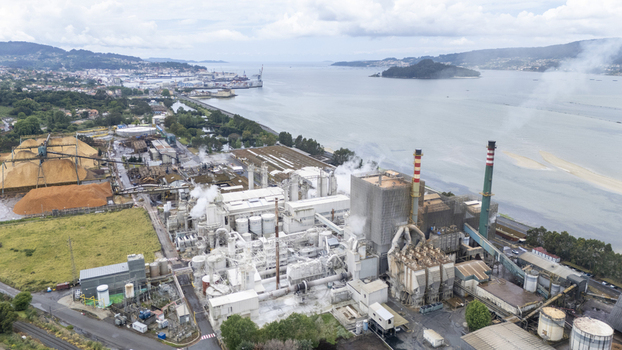 Aerial view of the Biofabrica de Ence industrial complex with smoking chimneys and wood chip piles along the Ria de Pontevedra Pontevedra Pontevedra Spain. Aerial view of the Biofabrica de Ence industrial complex with smoking chimneys and wood chip piles along the Ria de Pontevedra Pontevedra Pontevedra Spain.