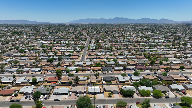 Aerial view of residential housing in the suburbs with grid patterned streets and distant mountains under a clear blue sky in Glendale Arizona United States. Aerial view of residential housing in the suburbs with grid patterned streets and distant mountains under a clear blue sky in Glendale Arizona United States.