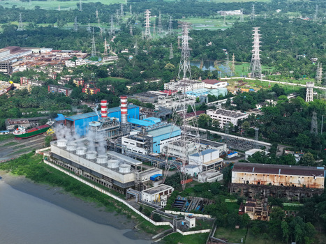Aerial view of the Raozan Power Plant along the Karnaphuli River with industrial buildings cooling towers and lush green vegetation in Chattogram Chattogram Division Bangladesh.