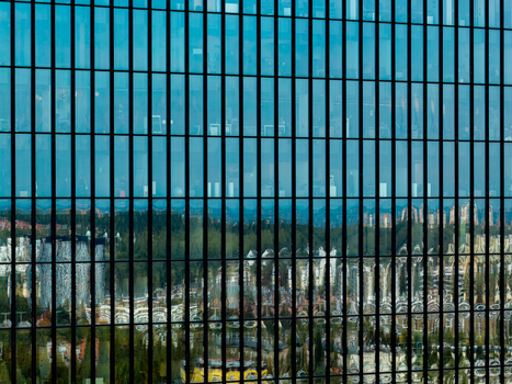Aerial view of the glass facade of a modern office building reflecting the surrounding urban landscape and greenery in Katowice Silesian Voivodeship Poland. Aerial view of the glass facade of a modern office building reflecting the surrounding urban landscape and greenery in Katowice Silesian Voivodeship Poland.