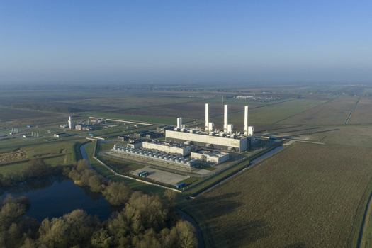 Aerial view of the nitrogen plant with tall chimneys and industrial buildings surrounded by flat agricultural fields and a small pond Zuidbroek Groningen Netherlands. Aerial view of the nitrogen plant with tall chimneys and industrial buildings surrounded by flat agricultural fields and a small pond Zuidbroek Groningen Netherlands.