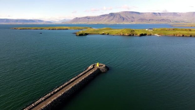 Aerial view of a yellow lighthouse on a breakwater in Iceland. Aerial view of a yellow lighthouse on a breakwater in Iceland.