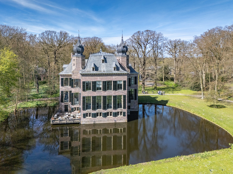 Aerial view of the stately Landgoed Oud Poelgeest reflecting serenely in the surrounding moat under a bright sky Oegstgeest Zuid Holland Netherlands. Aerial view of the stately Landgoed Oud Poelgeest reflecting serenely in the surrounding moat under a bright sky Oegstgeest Zuid Holland Netherlands.
