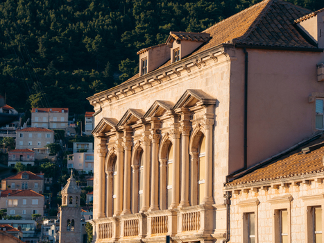 View of the ornate stone facade of a historic building with arched windows and columns under warm sunlight in the Dubrovnik Old Town Dubrovnik Dubrovnik Neretva County Croatia. View of the ornate stone facade of a historic building with arched windows and columns under warm sunlight in the Dubrovnik Old Town Dubrovnik Dubrovnik Neretva County Croatia.