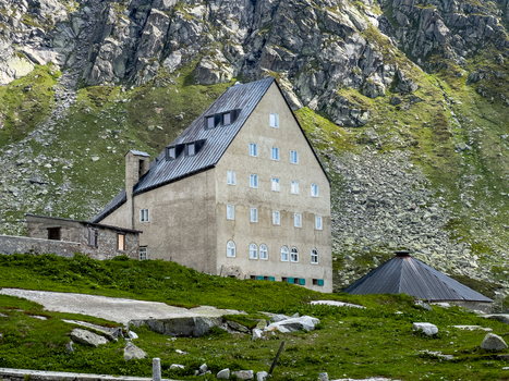 View of the historic Ospizio San Gottardo building at the Sankt Gotthard Pass surrounded by rugged rocky mountain slopes Airolo Ticino Switzerland.