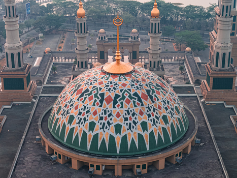 Aerial view of the Baitul Muttaqien Mosque at the East Kalimantan Islamic Center featuring its large intricately patterned dome and tall minarets in Samarinda East Kalimantan Indonesia.