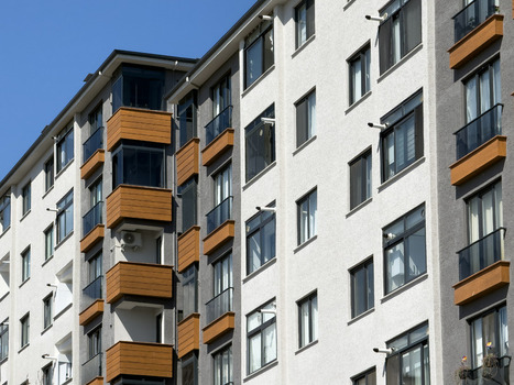 View of modern residential apartment building facade with wooden balcony accents and glass windows under a clear blue sky in Avcilar Istanbul Turkiye. View of modern residential apartment building facade with wooden balcony accents and glass windows under a clear blue sky in Avcilar Istanbul Turkiye.