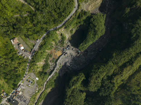 Aerial view of Tambang Pasir Merapi Kali Gendol Sand Mine with heavy machinery and trucks surrounded by lush green forest in Kecamatan Cangkringan Daerah Istimewa Yogya Indonesia. Aerial view of Tambang Pasir Merapi Kali Gendol Sand Mine with heavy machinery and trucks surrounded by lush green forest in Kecamatan Cangkringan Daerah Istimewa Yogya Indonesia.