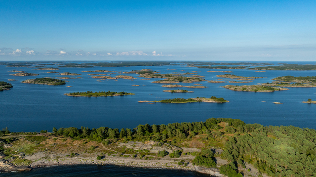 Aerial view of the Oro Fortress Island archipelago featuring lush pine forests rocky coastlines and small islands scattered across the calm blue sea in Oro Varsinais Suomi Finland. Aerial view of the Oro Fortress Island archipelago featuring lush pine forests rocky coastlines and small islands scattered across the calm blue sea in Oro Varsinais Suomi Finland.