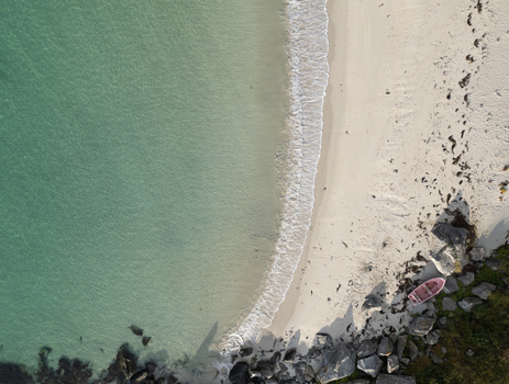 Aerial view of Vik Strand beach with turquoise water white sand and a small pink boat on the shore Leknes Nordland Norway. Aerial view of Vik Strand beach with turquoise water white sand and a small pink boat on the shore Leknes Nordland Norway.