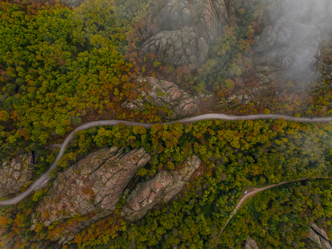 Aerial view of the unique Belogradchik Rocks surrounded by vibrant autumn forest and a winding road in Belogradchik Vidin Bulgaria. Aerial view of the unique Belogradchik Rocks surrounded by vibrant autumn forest and a winding road in Belogradchik Vidin Bulgaria.