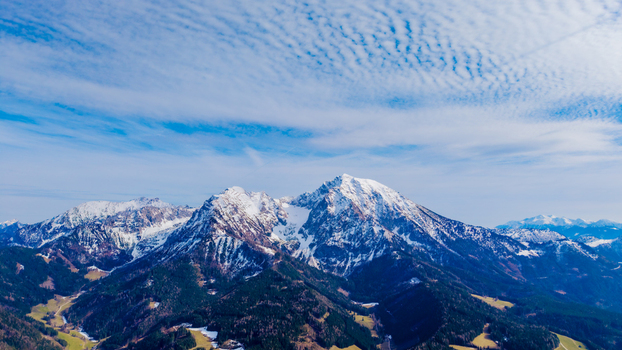Aerial view of snow dusted peaks pierce the sky their rugged slopes contrasting with the lush green valleys below Windischgarsten Upper Austria Austria. Aerial view of snow dusted peaks pierce the sky their rugged slopes contrasting with the lush green valleys below Windischgarsten Upper Austria Austria.