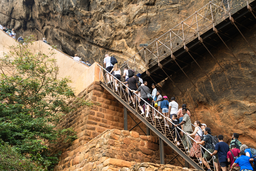 Sri Lanka 21 February 2026 View of tourists climbing the steep metal stairs attached to the ancient rock face of Sigiriya Rock Fortress.