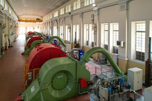 Aerial view of the Centrale idroelettrica di Villa with large red and green turbines inside the industrial hall in Ceresole Reale Piedmont Italy. Aerial view of the Centrale idroelettrica di Villa with large red and green turbines inside the industrial hall in Ceresole Reale Piedmont Italy.