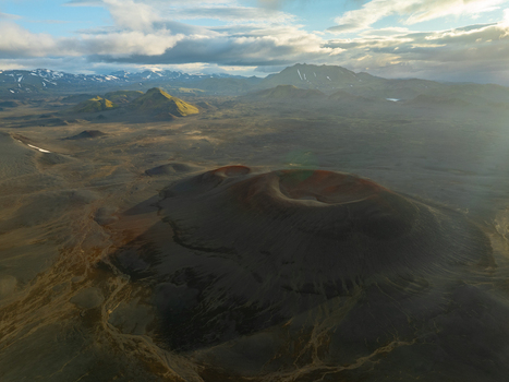 Aerial view of Landmannalaugar volcanic landscape with craters rugged terrain and distant mountains under a dramatic sky in Rangarthing ytra Iceland. Aerial view of Landmannalaugar volcanic landscape with craters rugged terrain and distant mountains under a dramatic sky in Rangarthing ytra Iceland.
